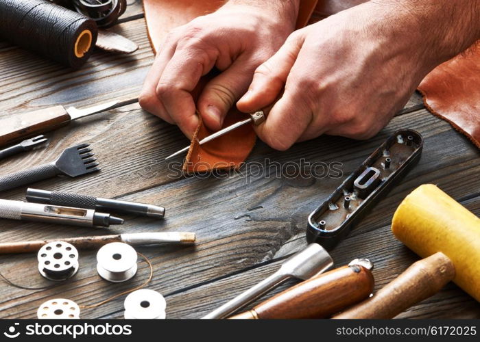 Man working with leather using crafting DIY tools