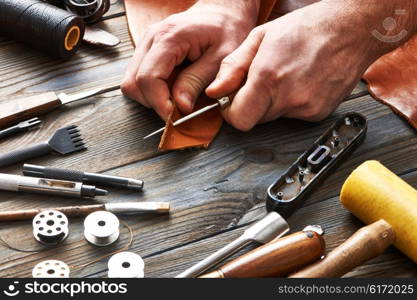 Man working with leather using crafting DIY tools