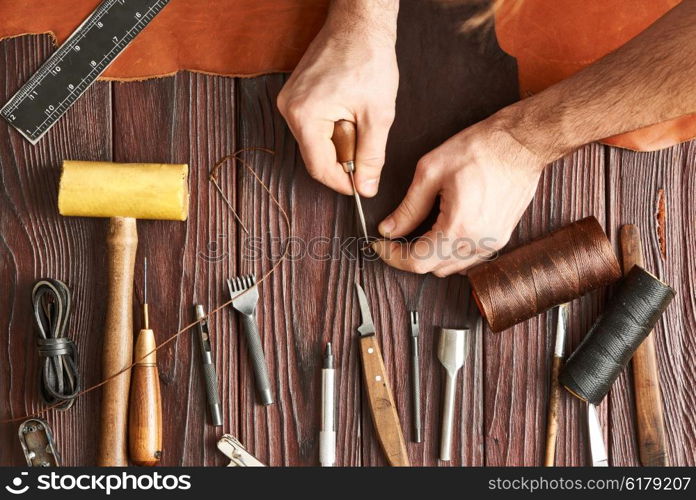 Man working with leather using crafting DIY tools