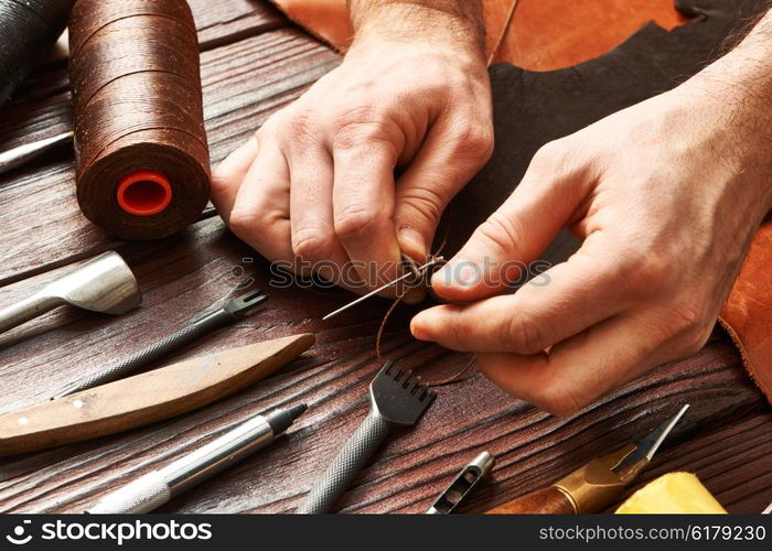 Man working with leather using crafting DIY tools