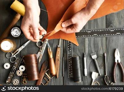 Man working with leather using crafting DIY tools