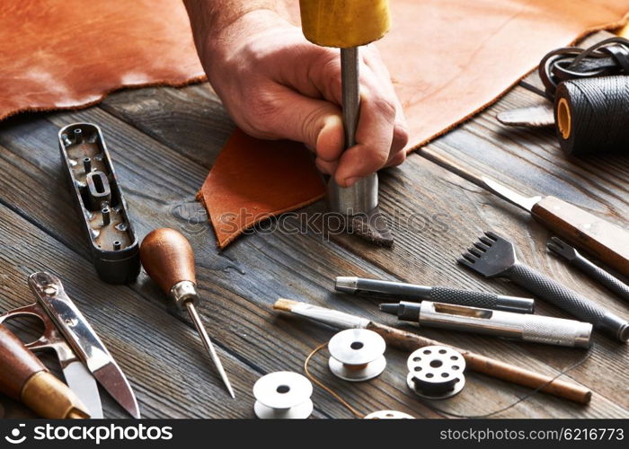 Man working with leather using crafting DIY tools