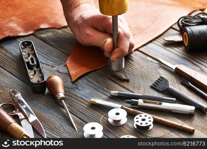 Man working with leather using crafting DIY tools