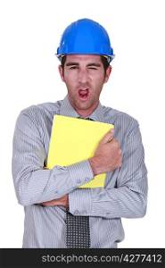 Man yawning whilst clutching paperwork