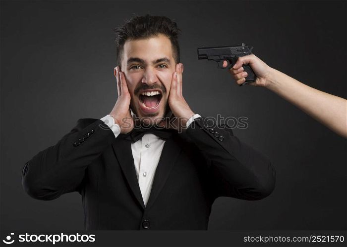 Man yelling with a weapon pointing on his head