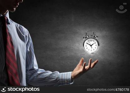 Manage your time. Close up image of human hand holding alarm clock
