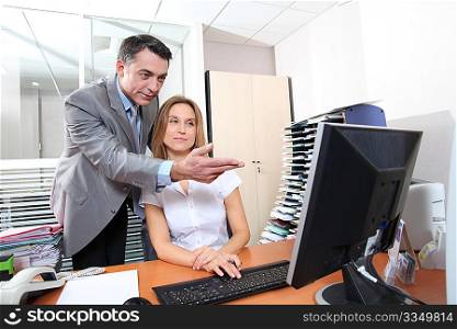 Manager and employee in front of computer in the office