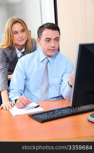 Manager and employee in front of computer in the office