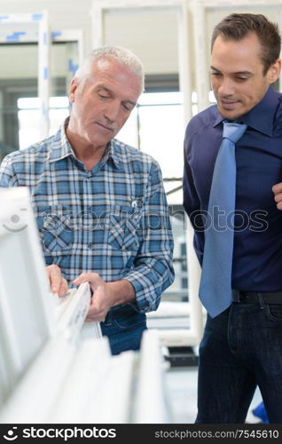 manager and engineer examining thread in textile mill