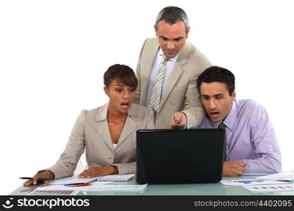 Manager and his shocked employees looking at a laptop
