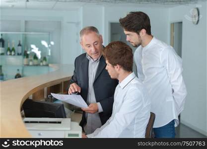 manager explaining something to his employee in a reception