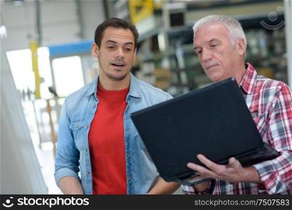 manager holding a laptop at the factory
