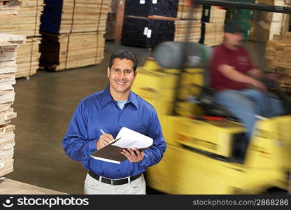 Manager in Lumber Warehouse Holding Clipboard