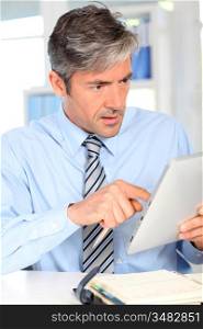 Manager in office using electronic tablet
