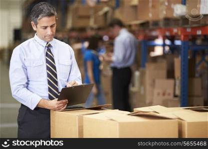 Manager In Warehouse Checking Boxes