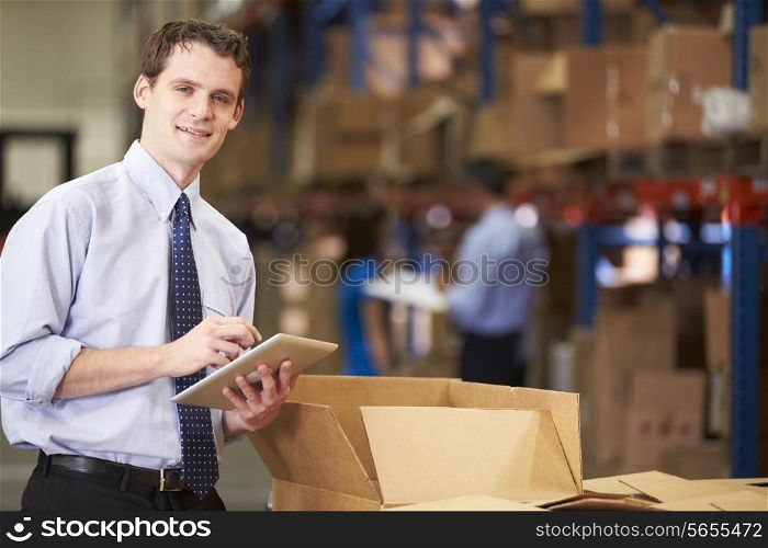 Manager In Warehouse Checking Boxes Using Digital Tablet