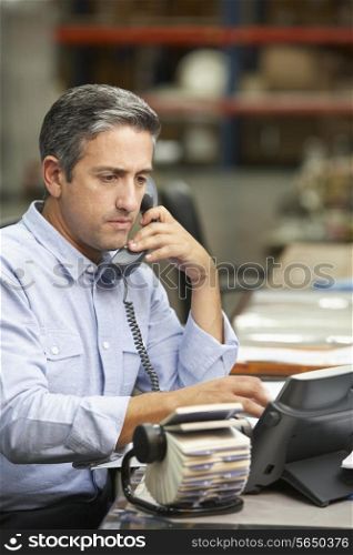 Manager Working At Desk In Warehouse