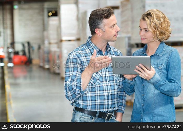 managers are looking a tablet in a warehouse