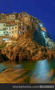Manarola. Village on the rock.. A view of the colorful traditional houses on the rock on sunset. The coast of Liguria. Manarola. Cinque Terre.