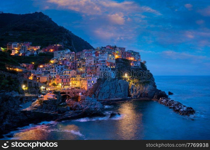 Manarola village popular european italian tourist destination in Cinque Terre National Park UNESCO World Heritage Site, Liguria, Italy illuminated in the evening. Manarola village in the night, Cinque Terre, Liguria, Italy