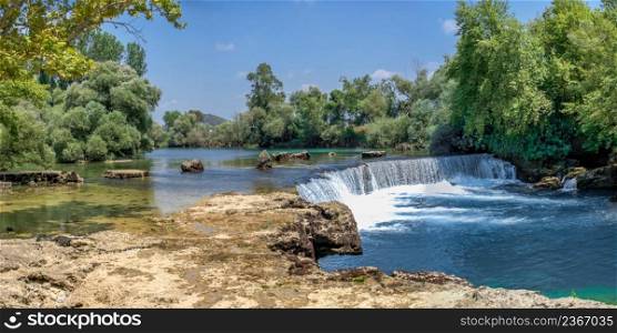 Manavgat waterfall and river in Antalya province of Turkey on a sunny summer day. Manavgat waterfall in Antalya province of Turkey