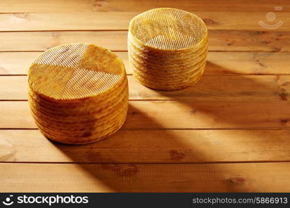 Manchego cheese from Spain in wooden table two whole pieces