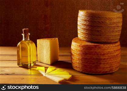 Manchego cheese from Spain in wooden table with andalusian olive oil