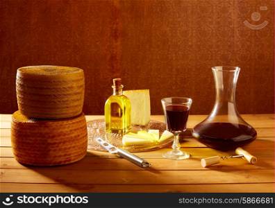 Manchego cheese from Spain with olive oil and red wine on wood