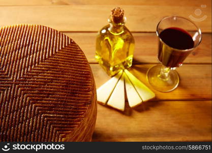 Manchego cheese from Spain with olive oil and red wine on wood