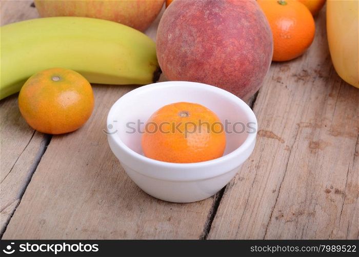 Mandarin Apples Bananas Peach on wooden plate