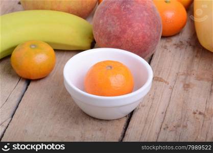 Mandarin Apples Bananas Peach on wooden plate