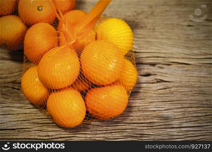 Mandarin orange in package on wood background with copy space