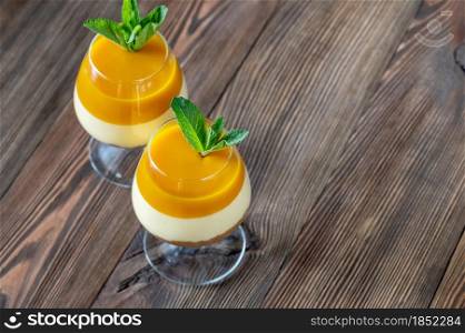 Mango cheesecake served in the glasses on rustic background