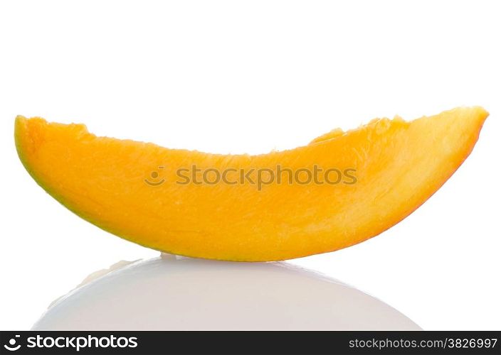 Mango fruit slice on white reflective background.