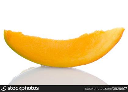 Mango fruit slice on white reflective background.