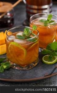 Mango iced tea with lime and mint. Refreshing organic soft drink
