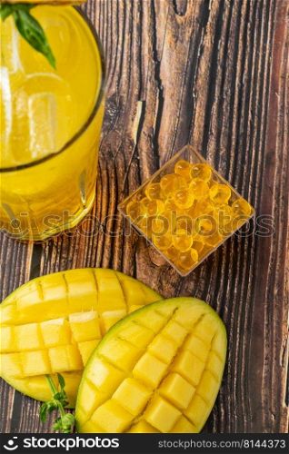 Mango lemonade with bubble tea on dark wooden background