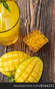 Mango lemonade with bubble tea on dark wooden background