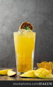 Mango lemonade with bubble tea on dark wooden background