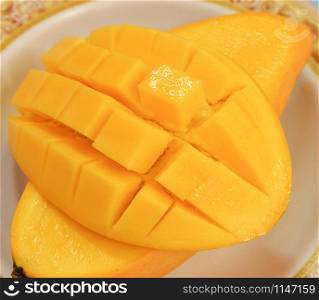 Mango tropical fruit sweet and ripe mango slice cube on plate close up
