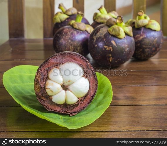 Mangostins and Fresh Green Leaf on Wooden Table