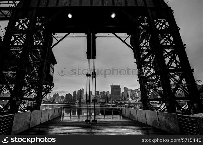 Manhattan New York cloudy skyline from East River floodgates structure USA