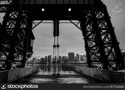 Manhattan New York cloudy skyline from East River floodgates structure USA