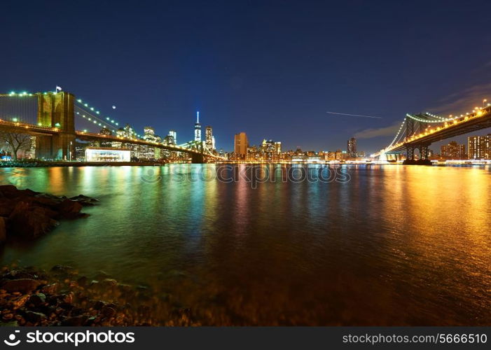 Manhattan skyline view at night from Brooklyn between Brooklyn Bridge and Manhattan Bridge in New York City