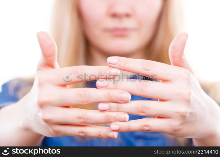 Manicure and hygiene concept. Blonde casual woman presents hands fingers. Girl with one hand coloured by hybrid nail polish and other without.. Woman presents hands nails.