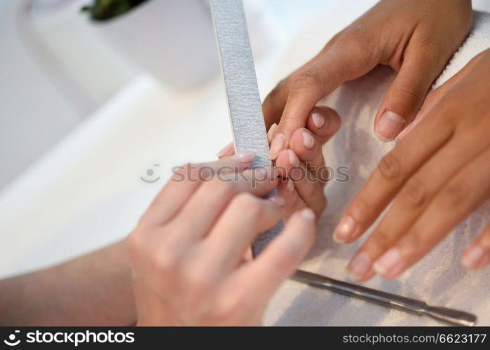 Manicure nail care for the client sitting at a table in the office. Beauty and Aesthetic concepts.