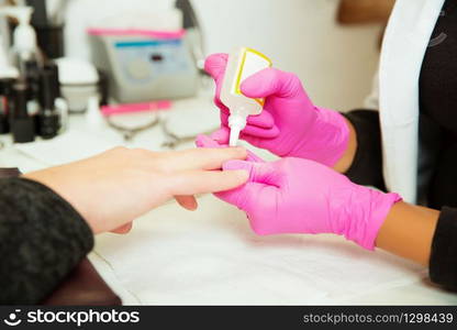 Manicure procedure with liquid for removal of cuticles. Professional manicure tool.