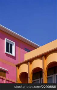 Manipulation techniques for architectural background design of colorful colonnade orange house with pink building against blue clear sky in perspective side view and vertical frame