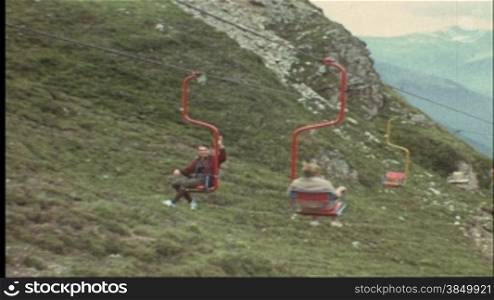 Mann fShrt mit dem Sessellift den Berg hinauf (8 mm-Film)