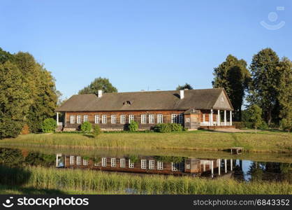 Manor house and pond in Trigorskoe village on sunset. State Museum-reserve of A. S. Pushkin, Pskov Region, Russia.